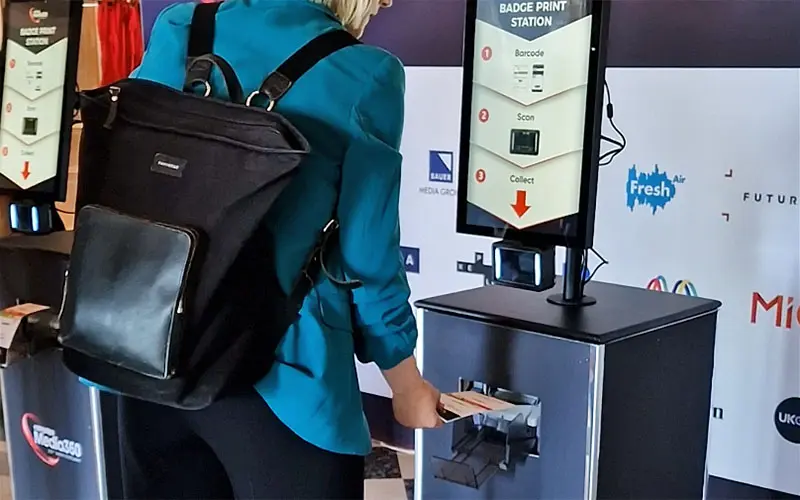Person collecting a badge from a Printpod